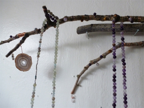 another detail with two necklaces hung on twigs.